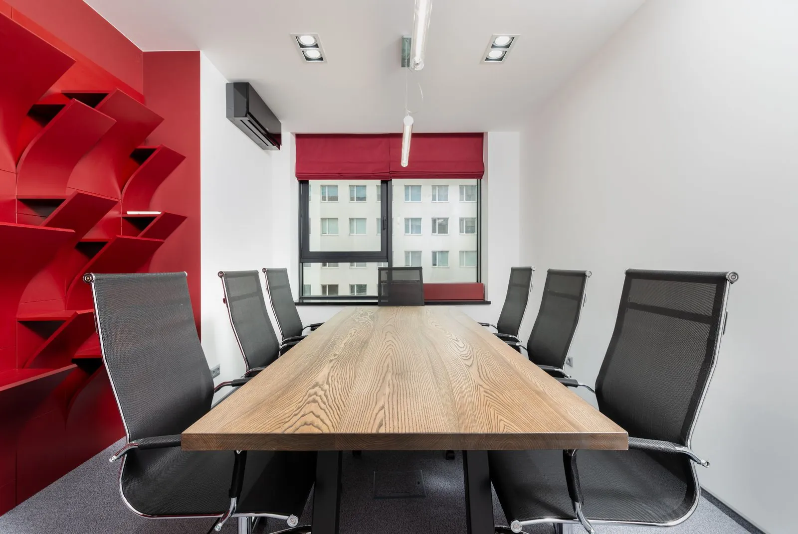 Sala de reunião com mesa em madeira e estante planejada